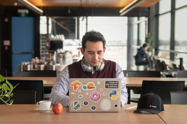 Services and Benefits: A person sits a laptop with coffee.